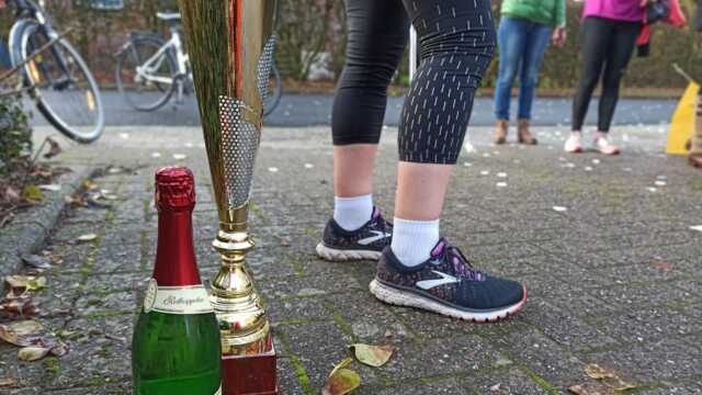 Freunde haben einen Pokal und eine Flasche Sekt besorgt. Beides wird nach der letzten Runde überreicht.